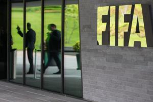 ZURICH, SWITZERLAND - MAY 27: A FIFA logo sits next to the entrance to the FIFA headquarters on May 27, 2015 in Zurich, Switzerland. Swiss police on Wednesday raided a Zurich hotel to detain top FIFA football officials as part of a US investigation into corruption. (Photo by Philipp Schmidli/Getty Images)